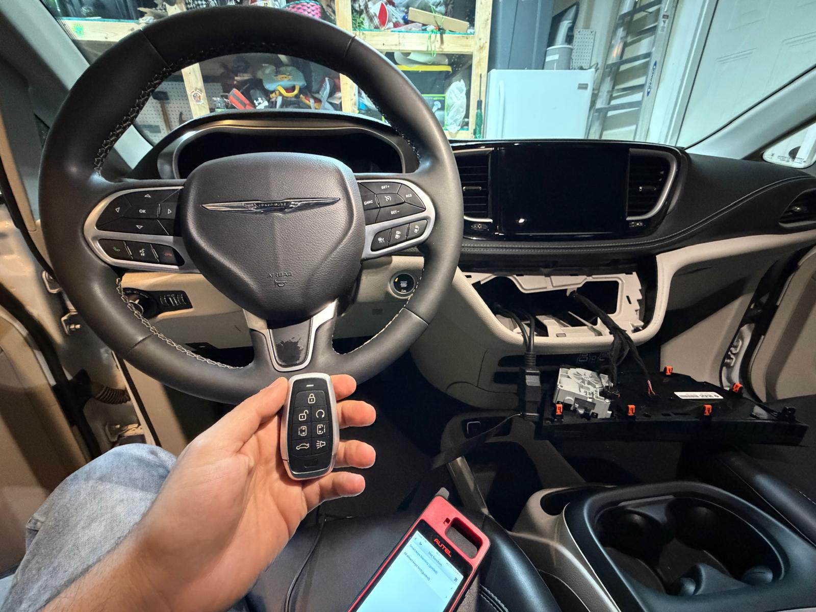 Chrysler minivan dashboard panel disassembled during transponder key programming using Autel tablet device during a custom Locksmith Services job in Charlotte, NC