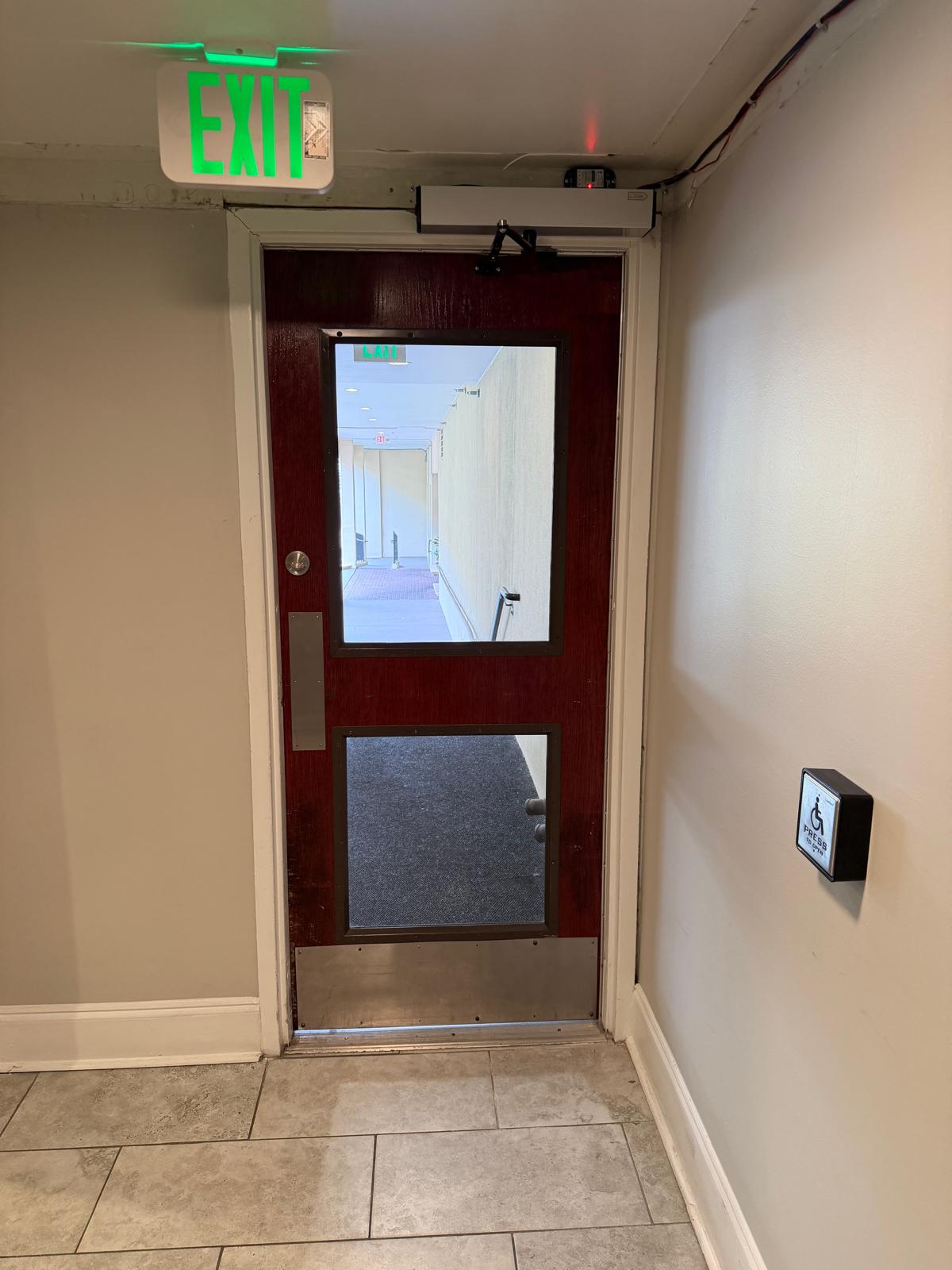 Commercial exit door equipped with automatic handicap door opener and panic bar emergency exit hardware during a custom Surveillance & Security Systems job in Charlotte, NC