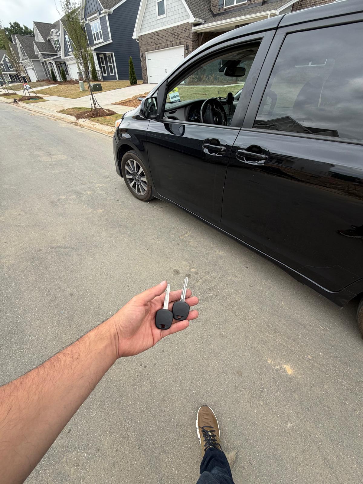 New keys cut and programmed for a black Toyota Sienna minivan in a residential neighborhood during a custom Locksmith Services job in Charlotte, NC